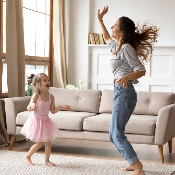 Photo of mother and child dancing in the living room