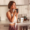 Woman in the kitchen drinking cup of tea